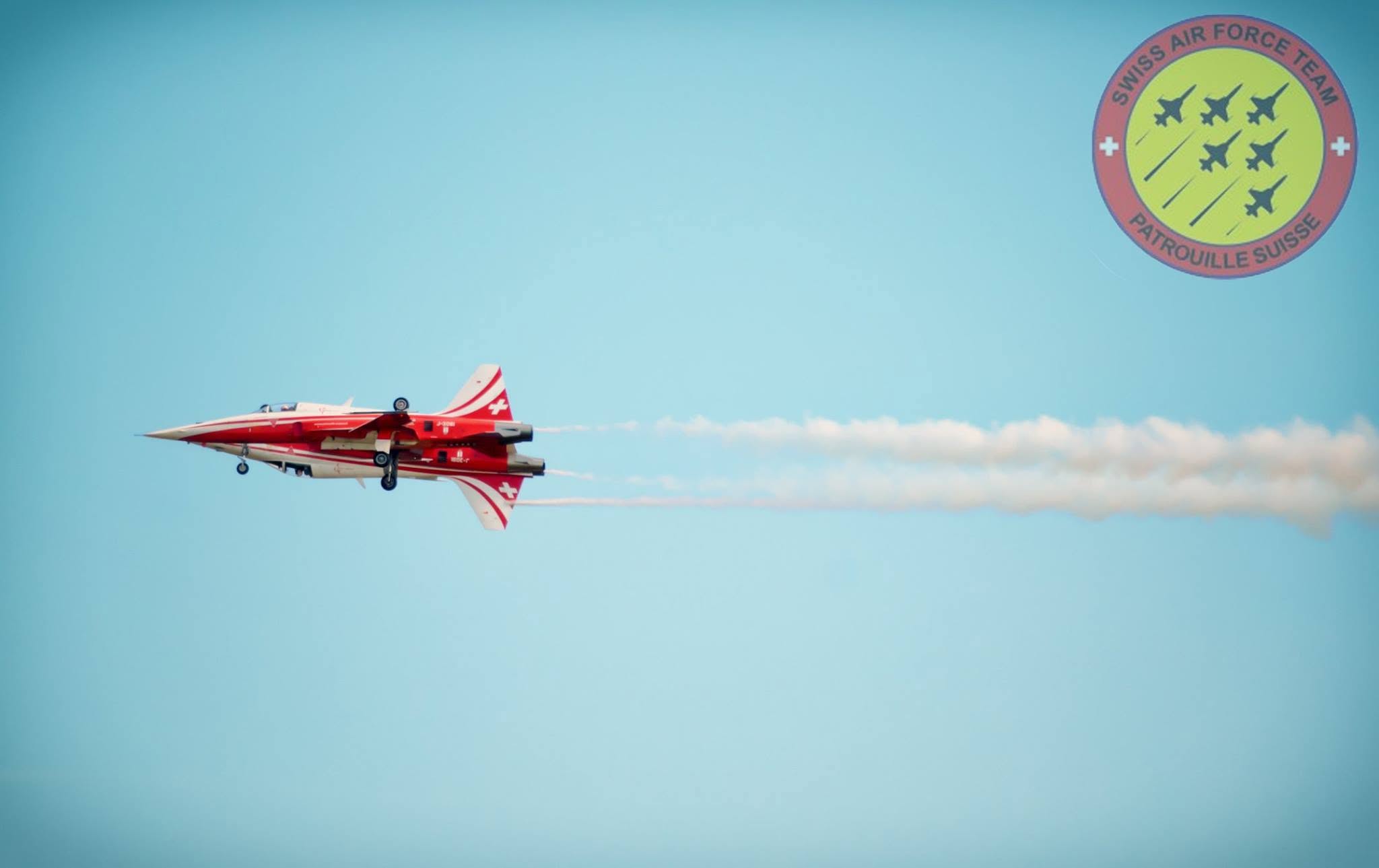 Rotes Flugzeug mit Rauchspur am Himmel